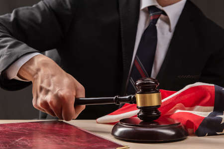 Judge hits the table with hammer. In the courtroom, the judge convicted lawyer. Judge`s gavel in hand close upの写真素材