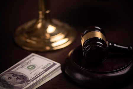 Judge gavel and money on brown wooden table concept close up