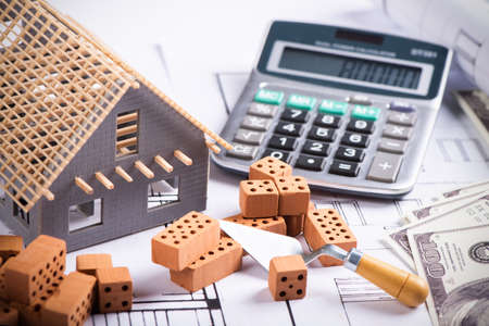 House model on background of US one hundred dollar bills close up