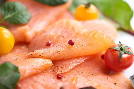 Closeup of some slices of smoked salmon on white plateの写真素材