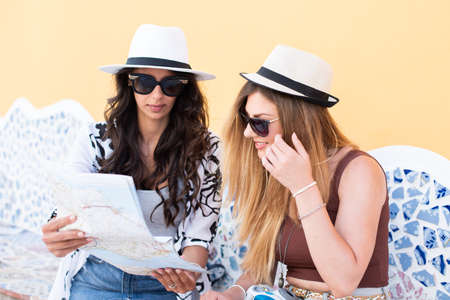 Young Traveler women sitting, taking photos and looking on a mapの写真素材