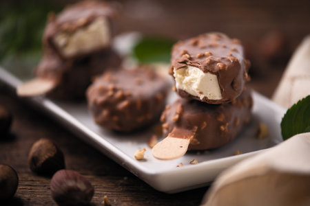 Chocolate ice lolly with almonds on the wooden vintage table. Close up