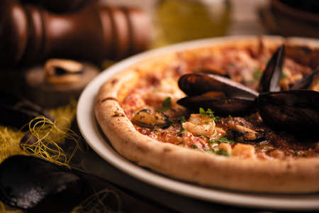 Pizza with mussels and shirmps on wooden board. sea food background close up