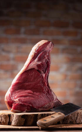 big raw piece of fiorentina meat on top a wooden table close upの写真素材