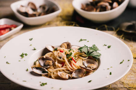 Closeup of spaghetti dish with clams served on a white dishの写真素材