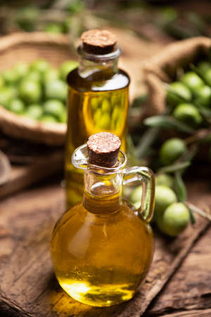 Extra virgin olive oil with fresh green olives close upの写真素材