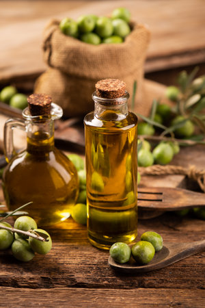 Extra virgin olive oil with fresh green olives close upの写真素材