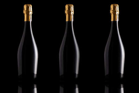 Three Champagne bottles isolated in a black backgroundの写真素材