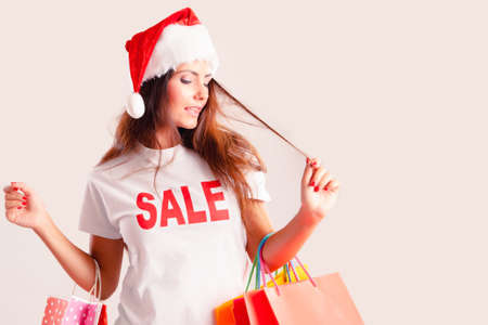 Christmas shopping brunette woman with shopping bags isolated on whiteの写真素材