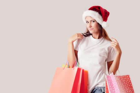 Christmas shopping brunette woman with shopping bags isolated on whiteの写真素材
