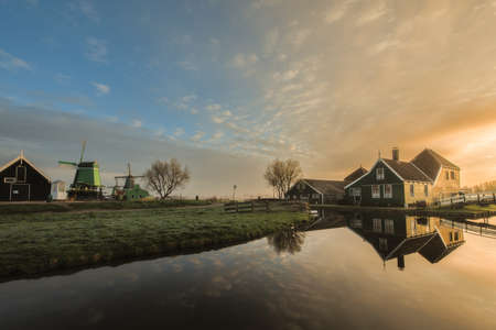 Traditional green dutch house with little wooden bridge against blue sky in the Zaanse Schans village. Holland Netherlandsの写真素材