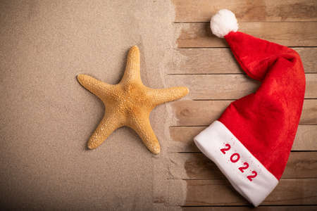 New Year 2022 written on a Santa Claus hat on sandy beach. Close upの写真素材