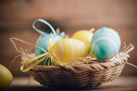 Easter eggs in the basket of wooden boards close upの写真素材