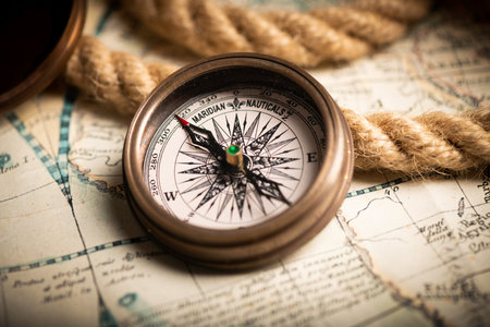 Antique compass lying on old style map close up