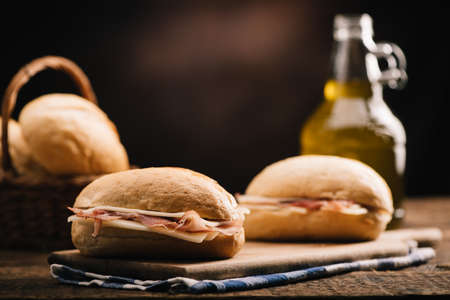 Two sandwiches with ham and cheese on wooden table close upの写真素材