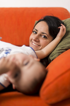 Mother and son playing on the couchの写真素材
