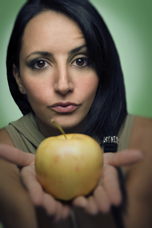 Sexy woman offering an appleの写真素材