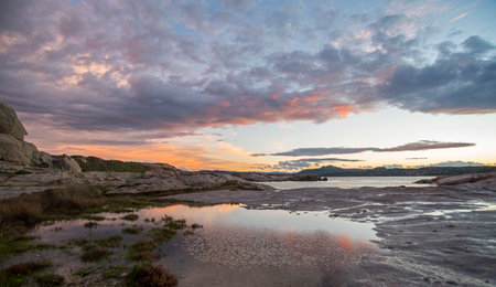 Sunset over the sea with beautiful clouds reflected in the water.の写真素材