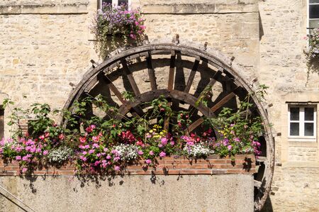 Mill wheel decorated with geranium flowersの写真素材