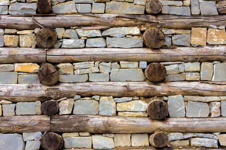old wall of logs and stones, form a geometric patternの写真素材
