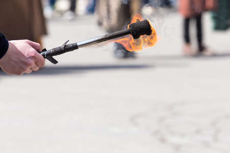hand holding a torch ignited during a show in the square