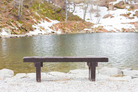 old wooden bench by the lake in the spring