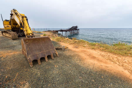 old excavator standing on the pier of the portの写真素材