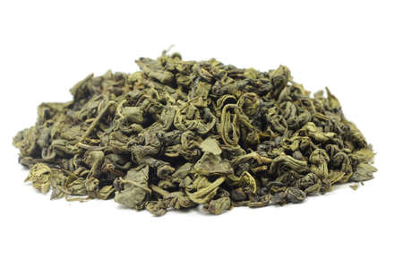 A handful of dried green tea leaves on white backgroundの写真素材