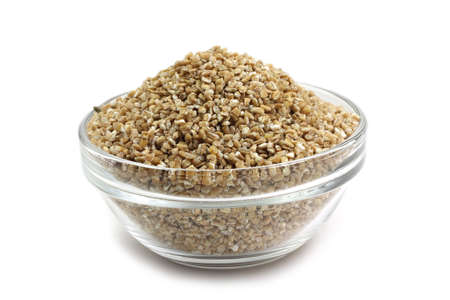  milled grain of wheat in a glass container on white backgroundの写真素材