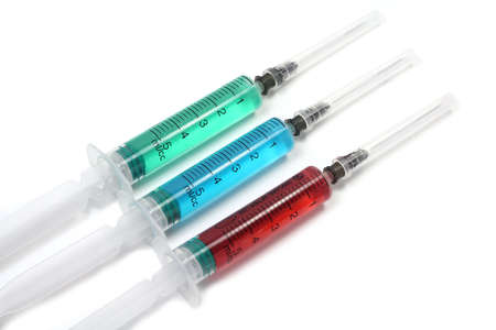 	Medical syringes with colored liquid on a white backgroundの写真素材