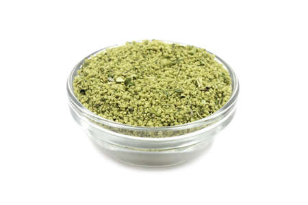granulated seasoning in a glass container on a white backgroundの写真素材
