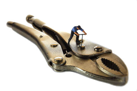 A little mechanic is tightening the wrench.の写真素材