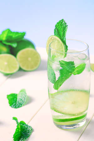 High glass of a drink with lime, ice cubes and mint for the summerの写真素材