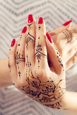 Red manicured hands with Mehndiの写真素材