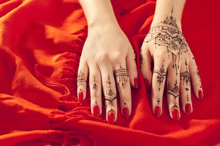 Red manicured hands with Mehndiの写真素材
