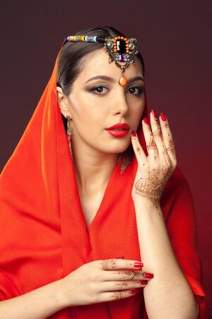 beautiful woman in oriental style with mehendi on dark backgroundの写真素材