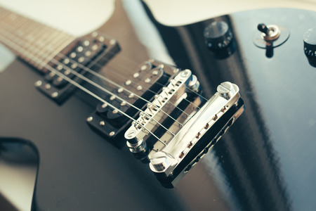 Electric guitar body and neck detail on wooden background