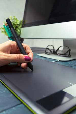 Hand of graphic designer working with stilus and tabletの写真素材