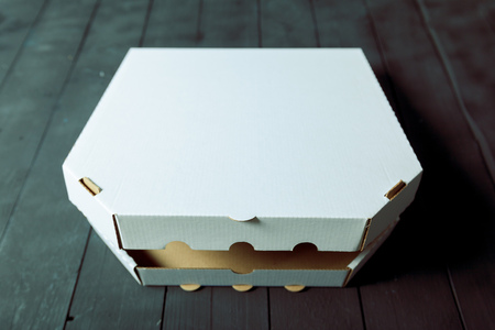 Empty cardboard pizza box on wooden tableの写真素材