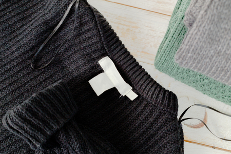 Stack of wool knitted warm sweater and white label for textの写真素材