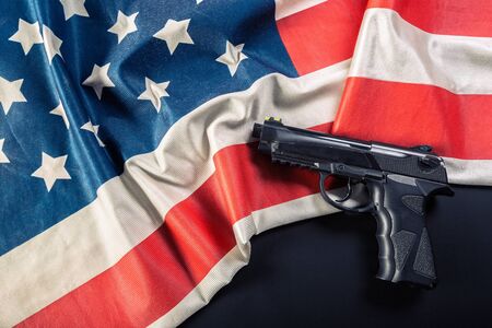 Handgun lying on American flagの写真素材