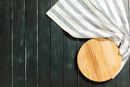 empty wooden board with tablecloth on dark deskの写真素材