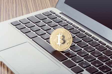 Golden bitcoin physical coin symbol on keyboardの写真素材