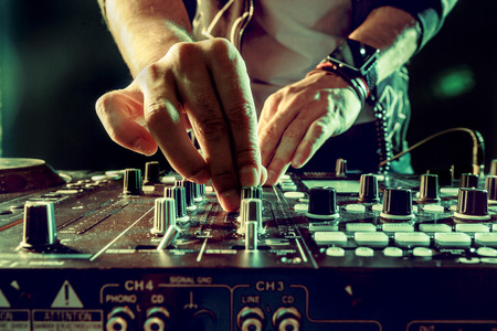 DJ playing music at mixer closeupの写真素材