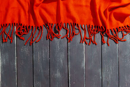 Red scarf over black wood table backgroundの写真素材