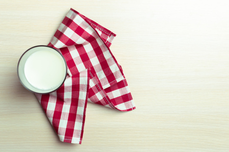 Glass of milk on table on blurred natural backgroundの写真素材