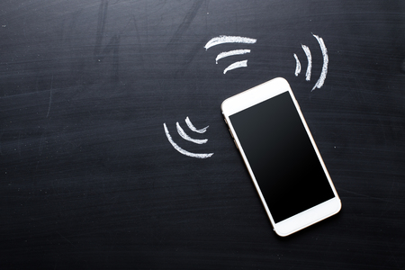 Smartphone on blackboard backgroundの写真素材
