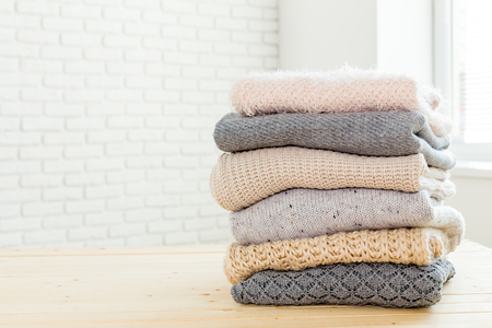 Stack of white cozy knitted sweatersの写真素材