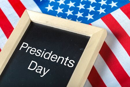 the text happy presidents day written in a chalkboard and a flag of the United Statesの写真素材