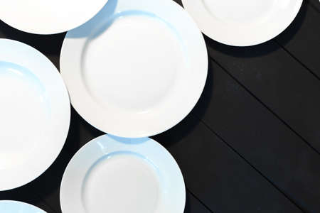 Empty white plates on wooden tableの写真素材